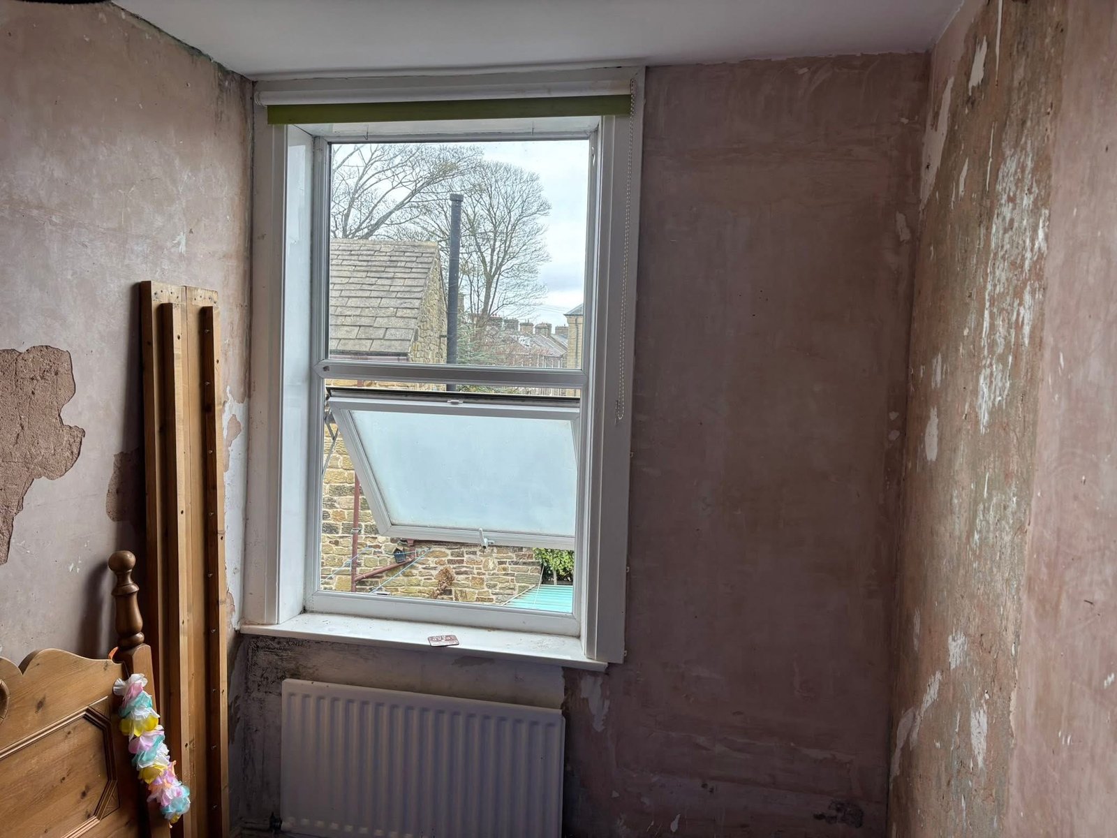 Living room wall before plastering, showing cracked plaster
